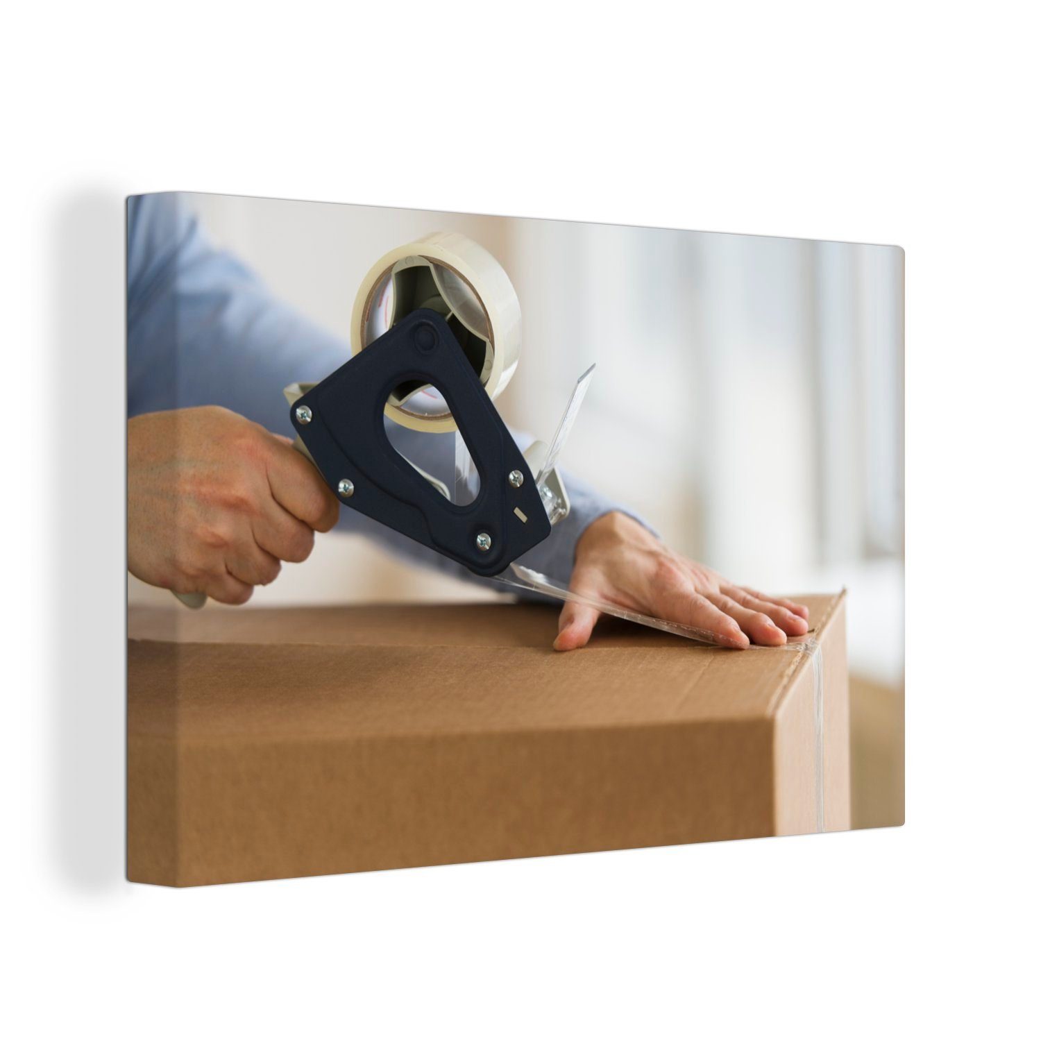 OneMillionCanvasses® Leinwandbild Person verschließt eine Schachtel mit Klebeband, (1 St), Wandbild Leinwandbilder, Aufhängefertig, Wanddeko, 30x20 cm