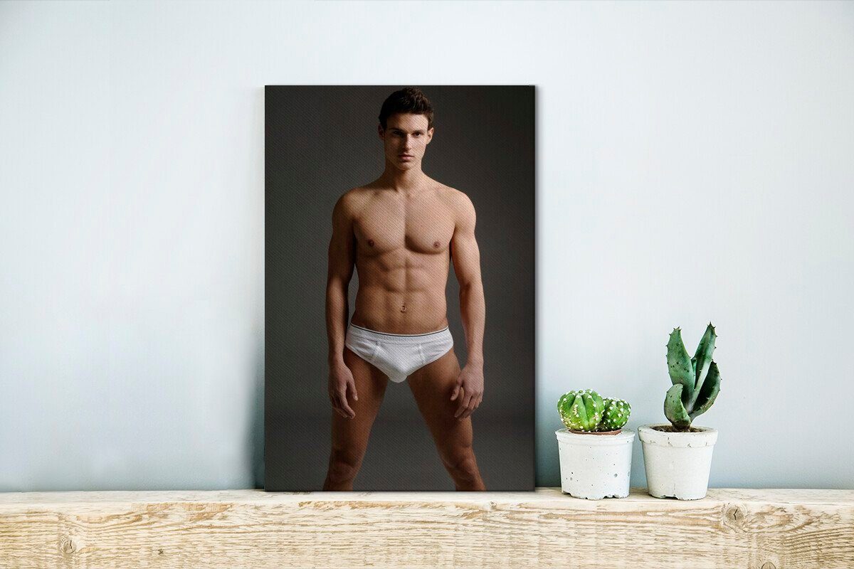 OneMillionCanvasses® Leinwandbild Ein Mann posiert weißen Zackenaufhänger, fertig 20x30 (1 in Leinwandbild Hosen, bespannt inkl. St), cm Gemälde