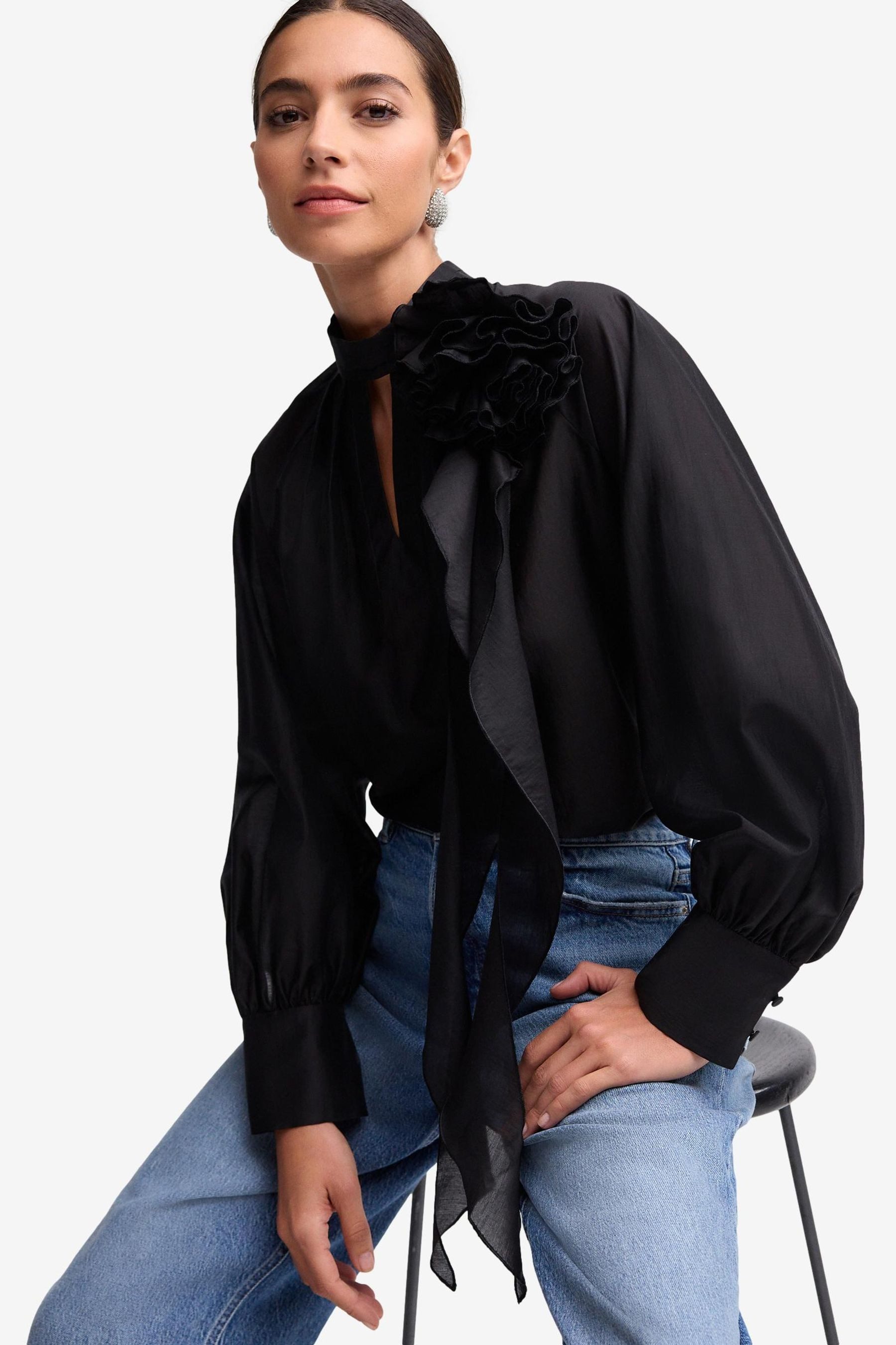Langarmbluse Langärmelige Bluse mit Rüschen und Blumengesteck