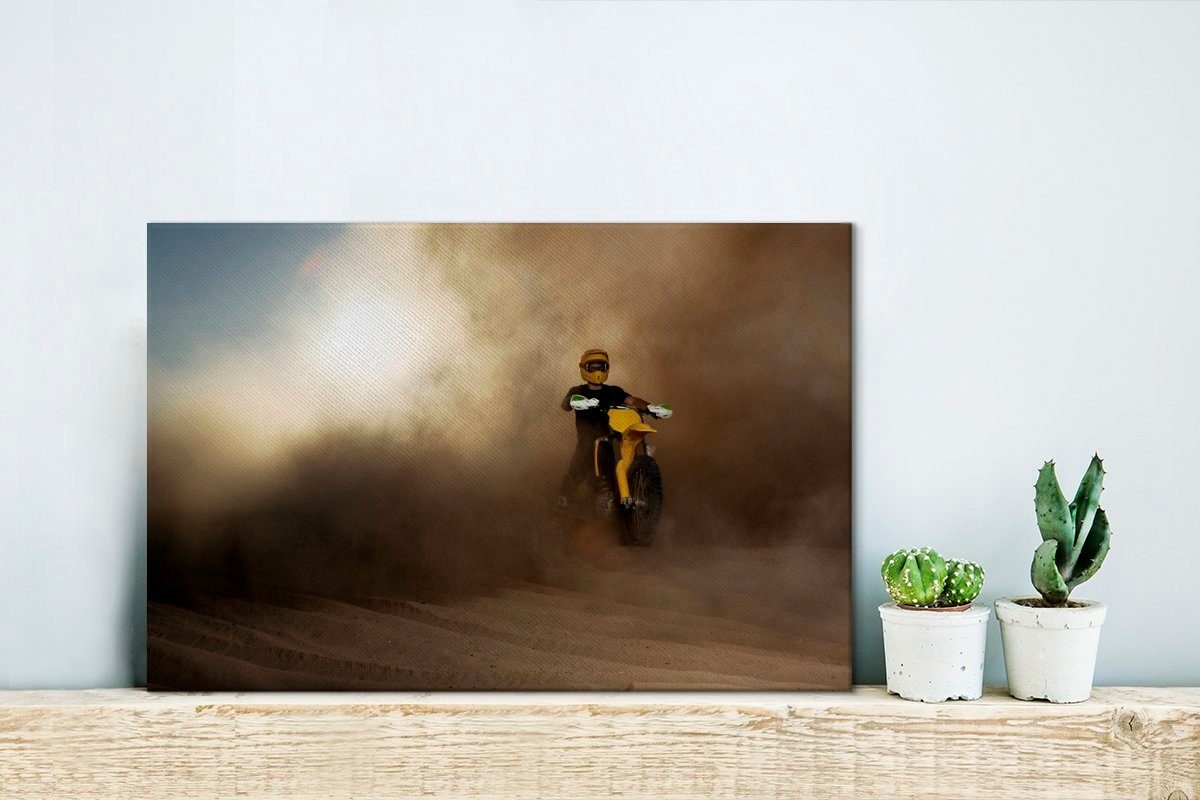 OneMillionCanvasses® Leinwandbild Ein Mann auf in (1 Wanddeko, Leinwandbilder, Staubwolke, gelben einem Motorrad Aufhängefertig, 30x20 Wandbild cm einer St)