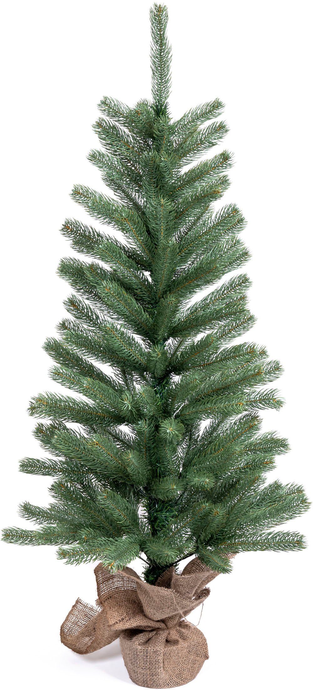 IC Winterworld Künstlicher Weihnachtsbaum Tannenbaum, künstlicher Christbaum, Nordmanntanne, Weihnachtsdeko mit Jutebeutel um den Betonfuß