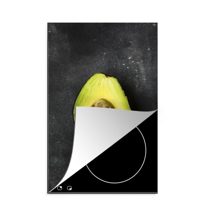 MuchoWow Herdblende-/Abdeckplatte Einsame Avocado auf einem schwarzen Tisch Vinyl (1 tlg) Küchen Dekoration für Induktionsherd Induktionskochfeld