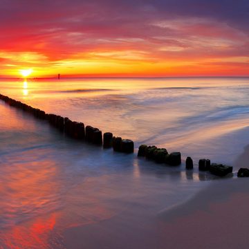 Wallario Möbelfolie Farbenspiel im Himmel - Sonnenuntergang am Strand
