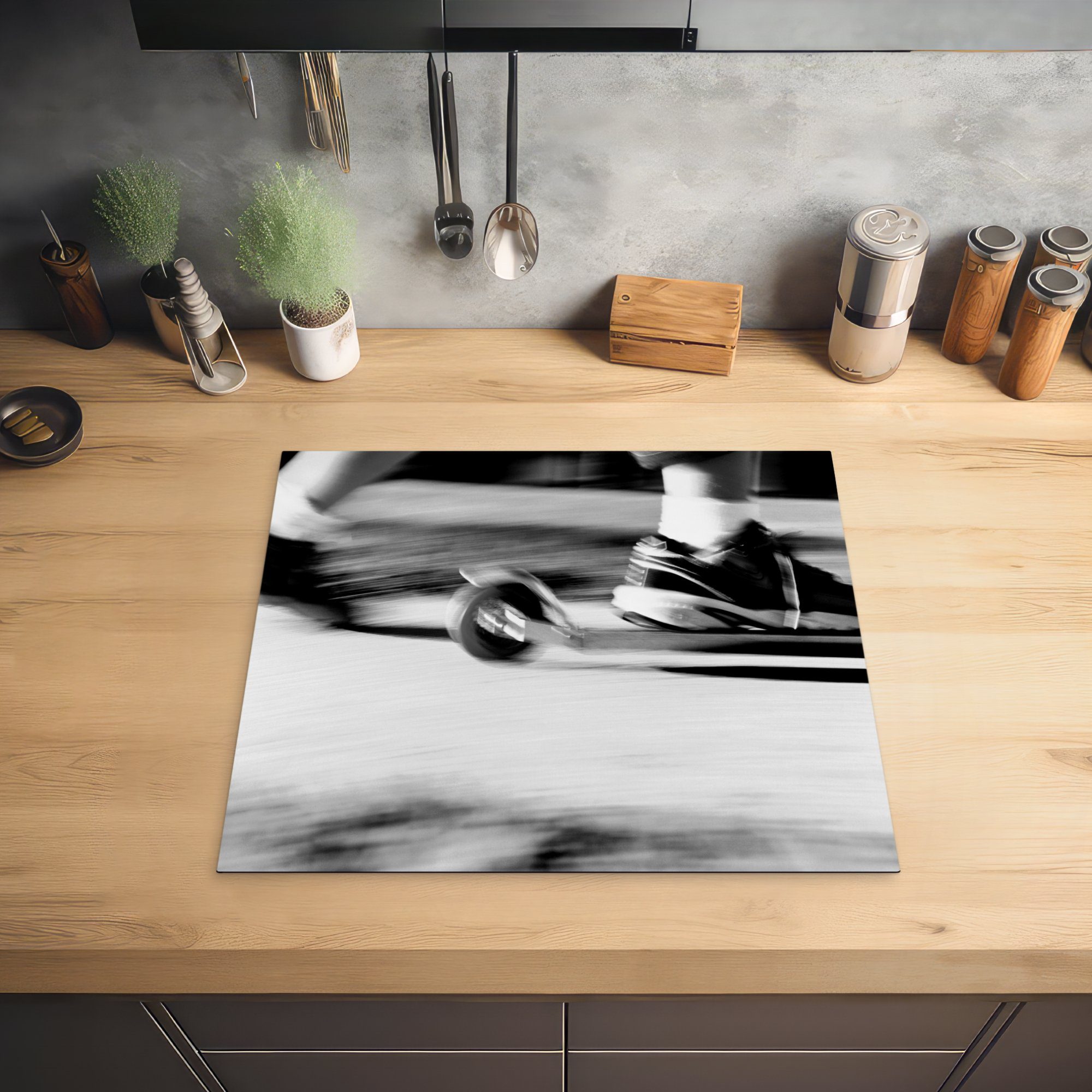 MuchoWow Herdblende-/Abdeckplatte Arbeitsfläche Ceranfeldabdeckung tlg), 60x52 Action-Foto eines (1 schwarz-weiß, cm, Mobile Vinyl, auf einem - nutzbar, Kindes Motorroller