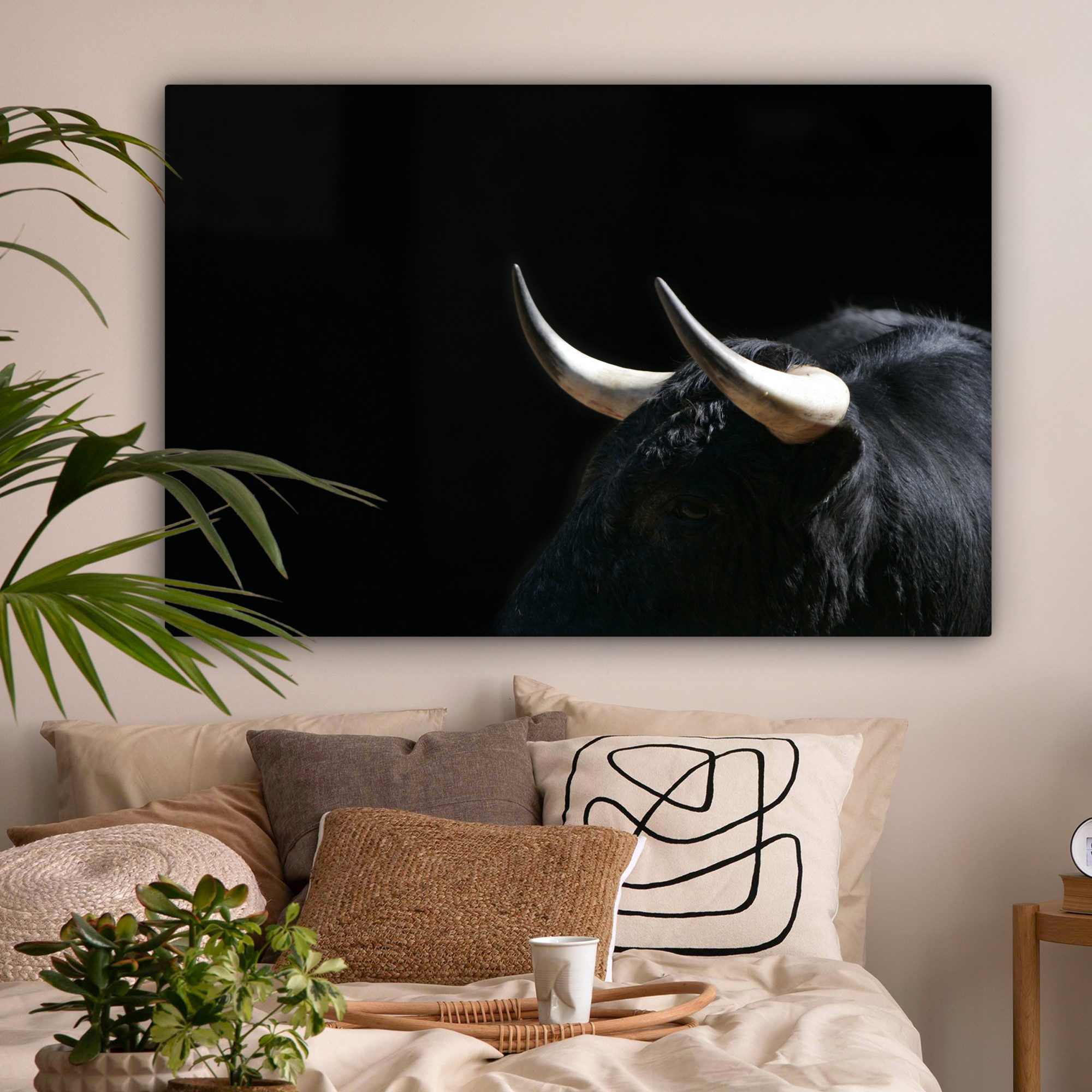 OneMillionCanvasses® Leinwandbild Ein Foto von einem schwarzen Stier vor einem schwarzen Hintergrund, Fotodruck (1 St), Leinwand Bilder groß für Wohnzimmer 140x90 cm