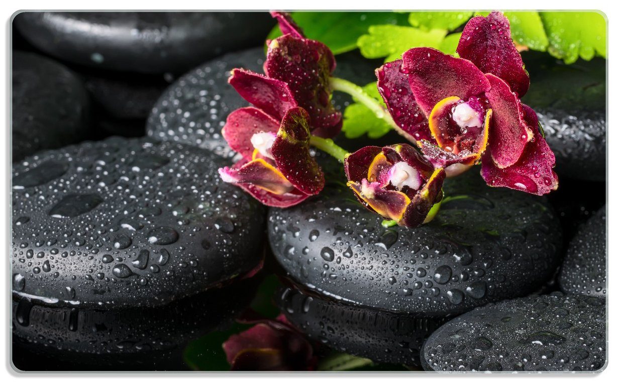 Wallario Frühstücksbrett Dunkelrote Orchideen-Blüte auf schwarzen Steinen mit Regentropfen, ESG-Sicherheitsglas, (inkl. rutschfester Gummifüße 4mm, 1-St), 14x23cm
