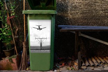 MuchoWow Wandsticker Sinkendes Flugzeug auf dem Weg zum Flughafen Schiphol - schwarz-weiß (1 St), Mülleimer-aufkleber, Mülltonne, Sticker, Container, Abfalbehälter