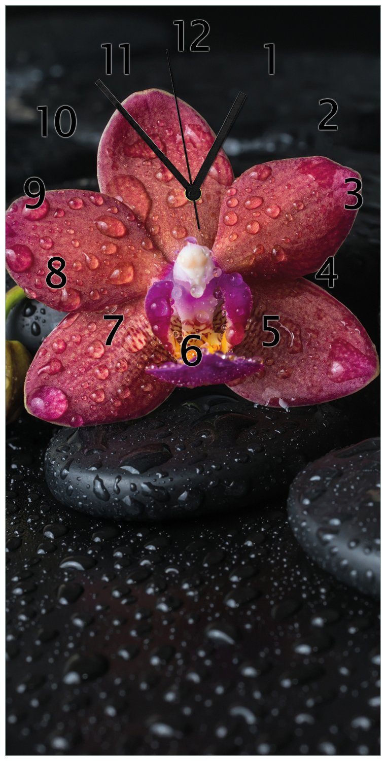 Wallario Wanduhr Orchideen-Blüte auf schwarzen Steinen, benetzt mit Wasser-Tropfen (Uhr aus Acryl)