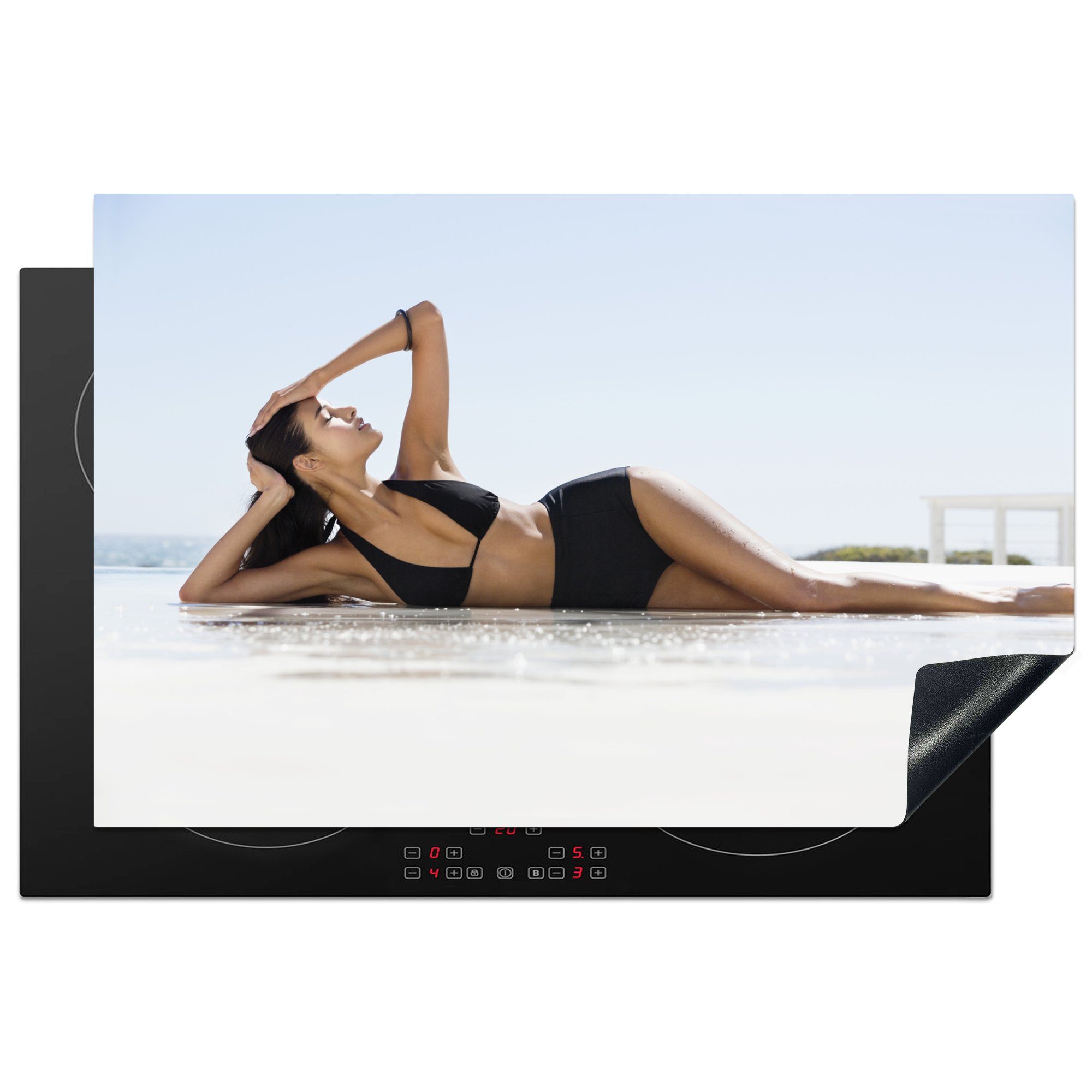 MuchoWow Herdblende-/Abdeckplatte Eine Frau in einem schwarzen Bikini posiert am Strand, Vinyl, (1 tlg), 81x52 cm, Induktionskochfeld Schutz für die küche, Ceranfeldabdeckung | Herdabdeckplatten