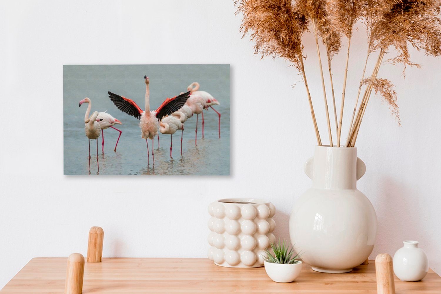 OneMillionCanvasses® Leinwandbild Ein Flamingo, der Wandbild Leinwandbilder, St), (1 Wanddeko, sich 30x20 ausstreckt, cm Aufhängefertig