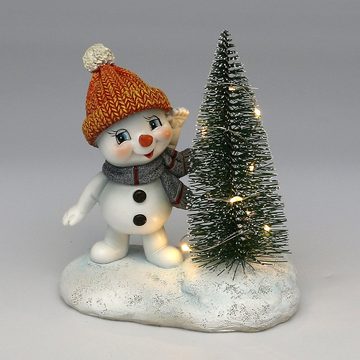 Dekohelden24 Dekofigur Schneekind - Schneemann mit Mütze und Schal in orange und grau, mit beleuchteten LED Weihnachtsbaum, L/B/H 12 x 7,5 x 14 cm.
