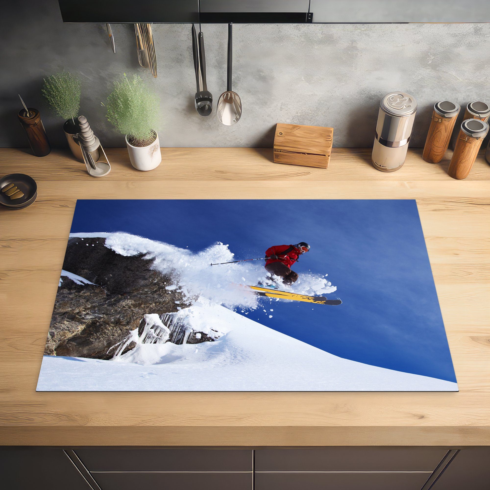 MuchoWow Herdblende-/Abdeckplatte Ein Skifahrer (1 einem küche, von die für macht Felsen, Schutz Induktionskochfeld Ceranfeldabdeckung Sprung schneebedeckten tlg), 81x52 cm, einen Vinyl
