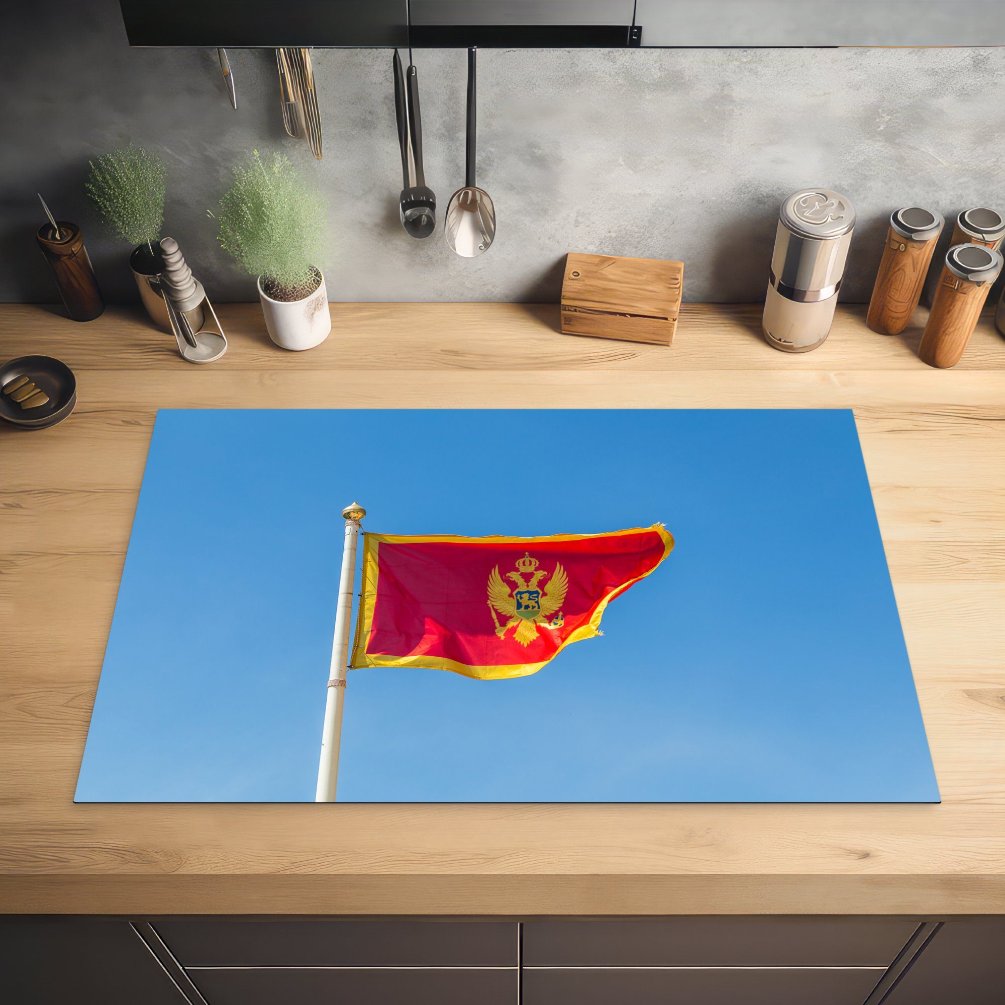 tlg), Montenegro blauen einem küche, für klaren (1 Induktionskochfeld MuchoWow cm, 81x52 vor Schutz von die Vinyl, Ceranfeldabdeckung Flagge Himmel, Herdblende-/Abdeckplatte