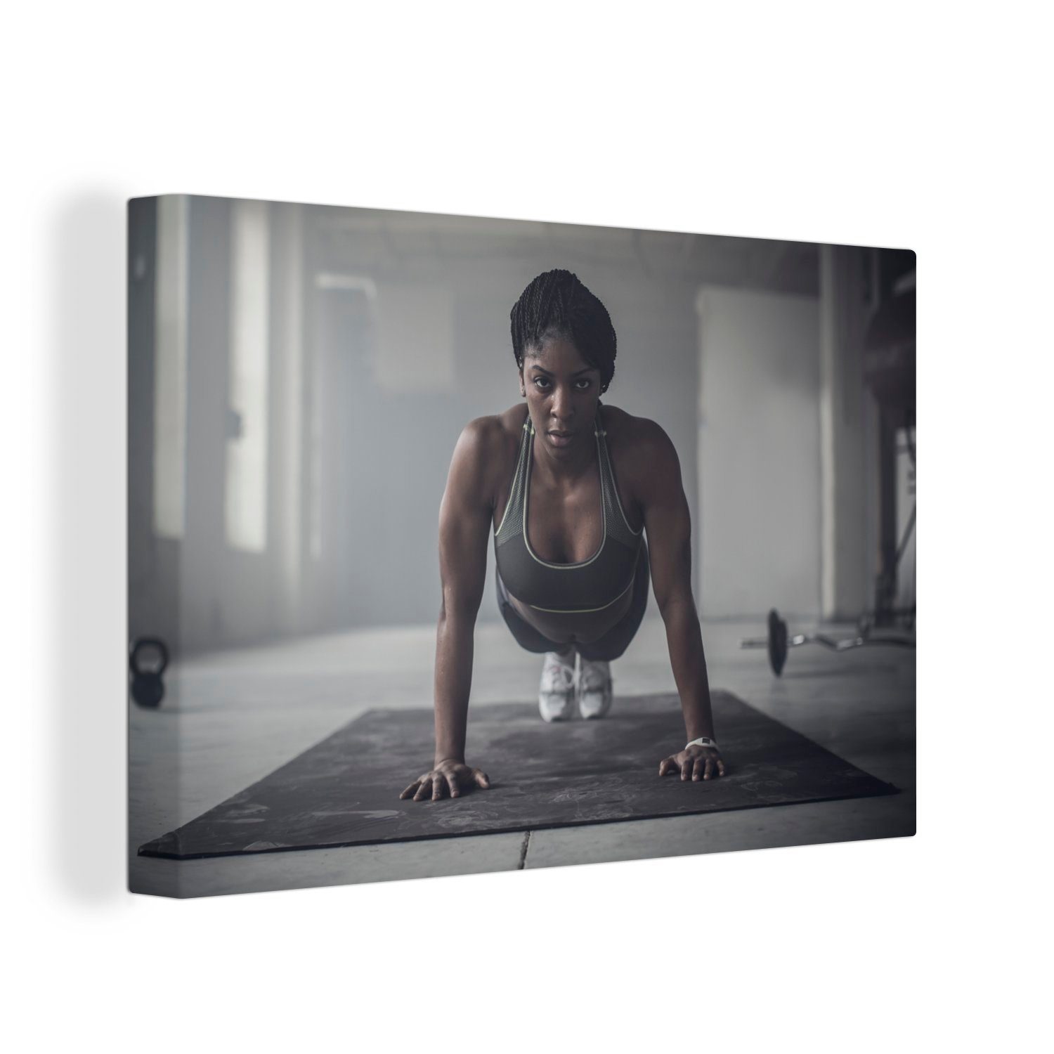 OneMillionCanvasses® Leinwandbild Eine Frau macht Liegestütze in einer dunklen Turnhalle, (1 St), Wandbild Leinwandbilder, Aufhängefertig, Wanddeko, 30x20 cm