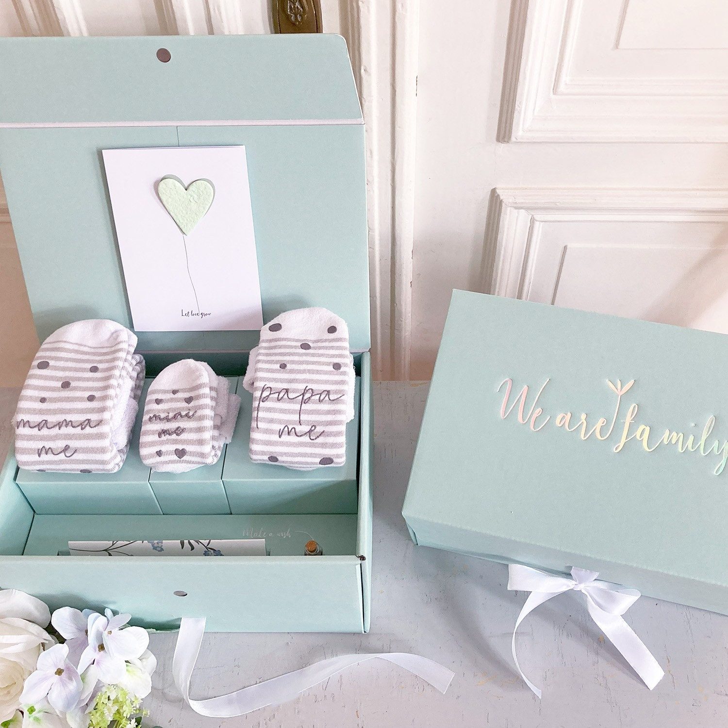 melovely Neugeborenen-Geschenkset "We Are Family" Geschenkbox, 6 Geschenke für Mama, Papa & Baby (Geschenkbox mit schöner Prägung, Seidenband und Magnetverschluss, 7-tlg., 3 Paar Bambus-Socken, Wunscherfüller, Grußkarte, Journalingheft) Geschenkbox zur Ge