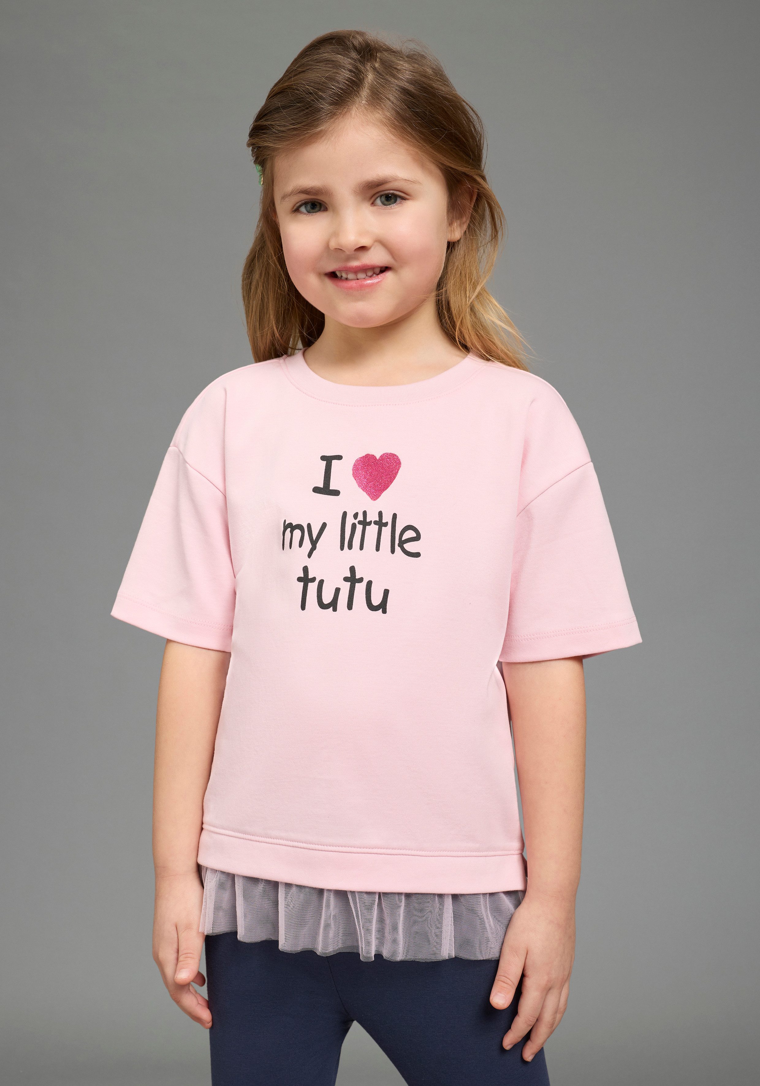 KIDSWORLD T-Shirt mit Glitzerprint und Tüll-Saum Basic Passform, Kurzarm, mit Volant aus Polyester. € 16,99, (€ 16,99 pro 1 Stk).