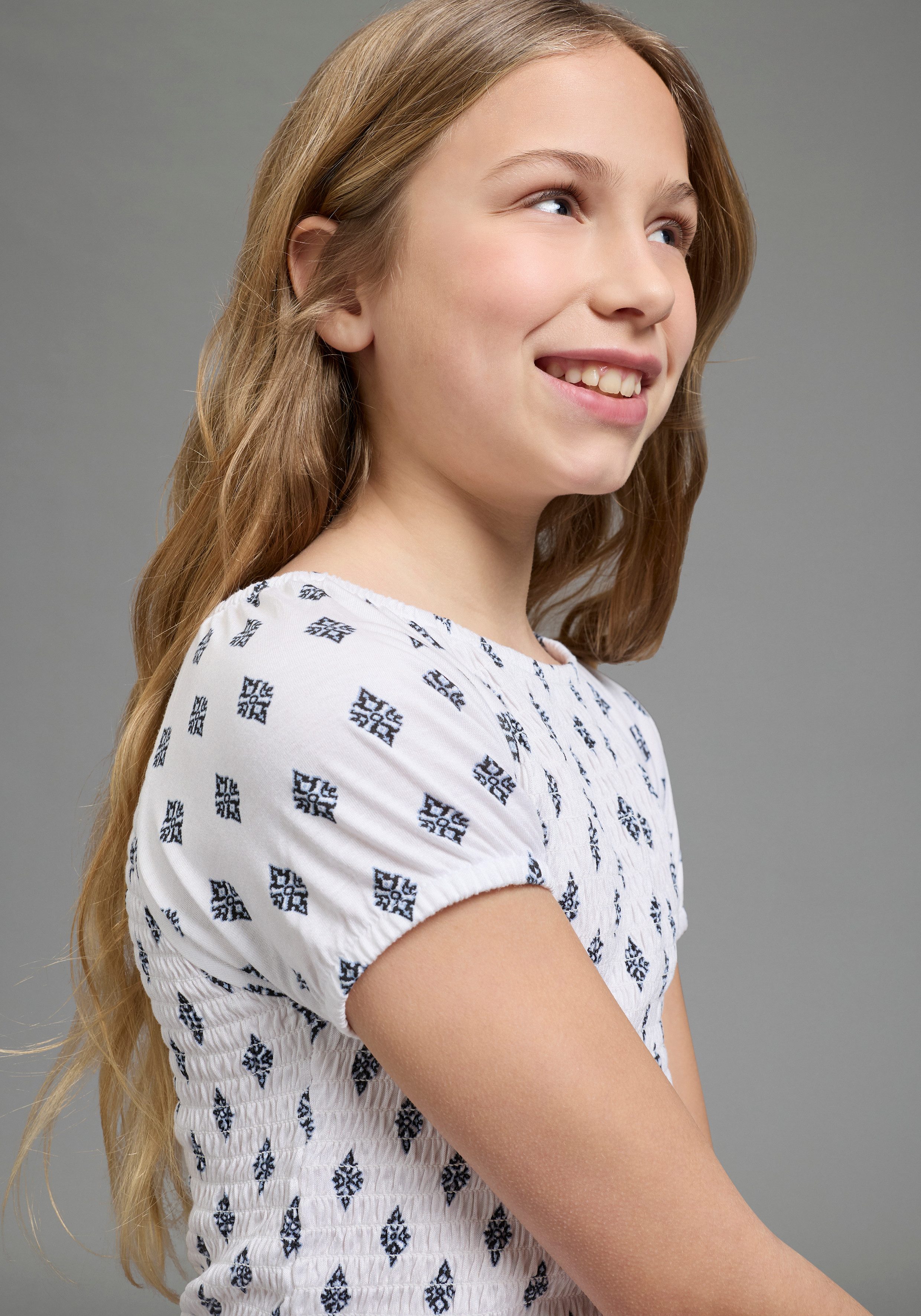 Bruno Banani Jerseykleid Viskose-Allover gemustertes Smoke Kleid, figurbetontes Carmenkleid für Mädchen, mit Carmenausschnitt, aus elastischem Jersey – Bild 4 von 5