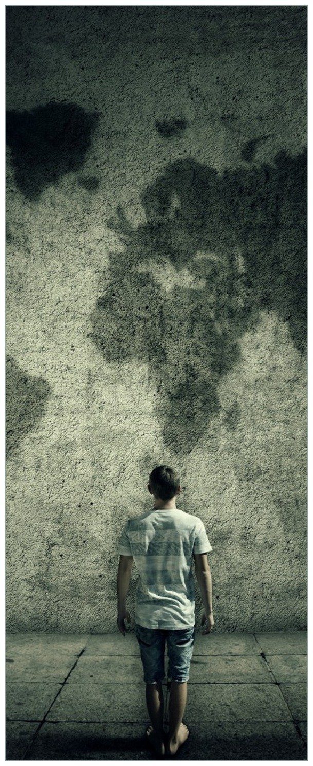 Wallario Memoboard Kleiner Junge vor Weltkarte an grauer Beton-Wand