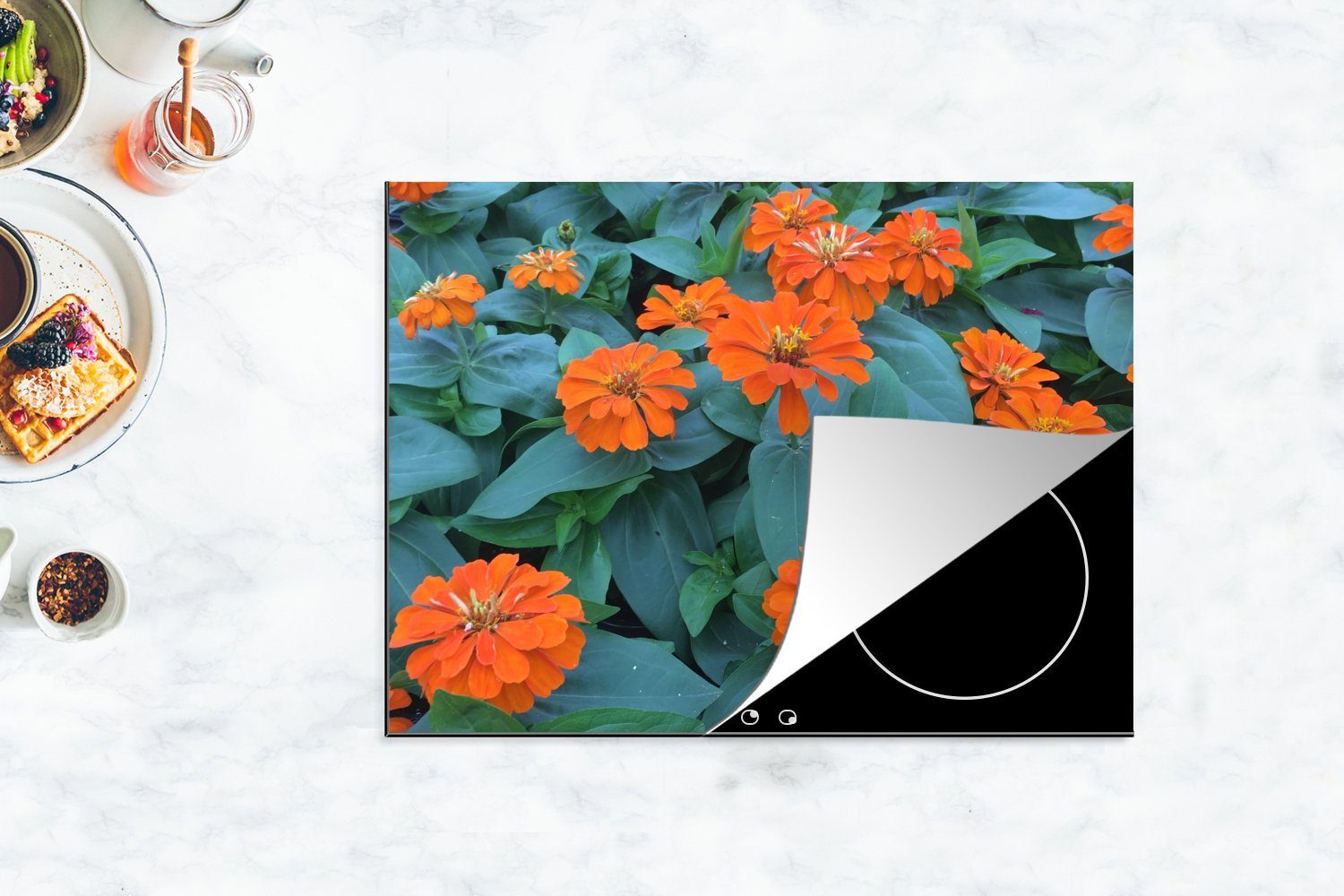 MuchoWow Herdblende-/Abdeckplatte Orangefarbene Zinnienblüten Vinyl, 70x52 Ceranfeldabdeckung grünen cm, mit nutzbar, (1 tlg), Blättern, Arbeitsfläche Mobile