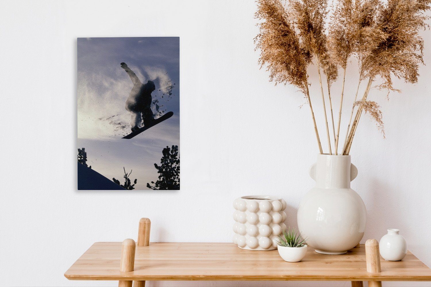 OneMillionCanvasses® Leinwandbild Ein Snowboarder hängt bespannt fertig Gemälde, Schnee cm Leinwandbild inkl. Zackenaufhänger, den in 20x30 der Luft (1 St), und mit, nimmt