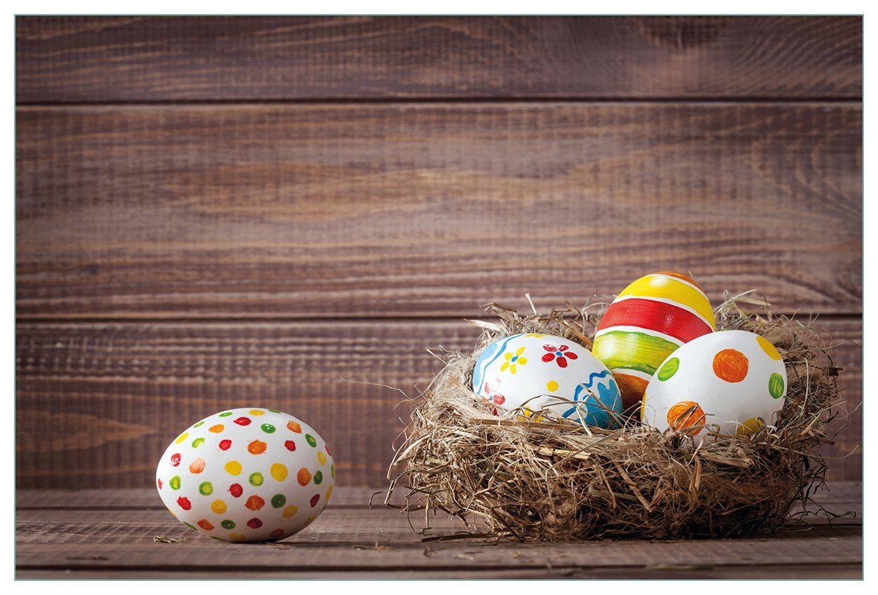 Wallario Küchenrückwand Bunte bemalte Eier vor Vorgelnest an Wand, Ostern im (1-tlg) hölzerner