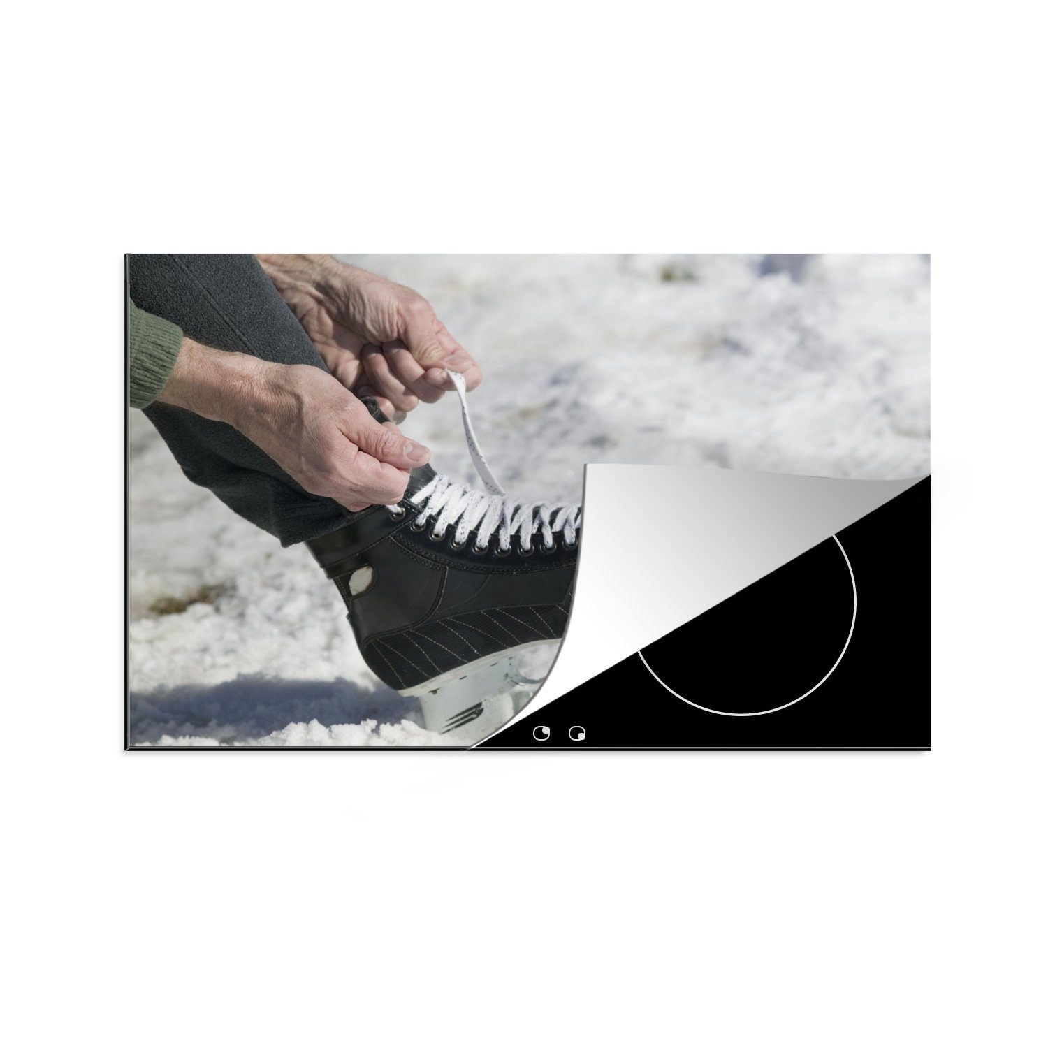 MuchoWow Herdblende-/Abdeckplatte Ein Mann bindet die Schnürsenkel seiner Schlittschuhe im Schnee, Vinyl, (1 tlg), 81x52 cm, Induktionskochfeld Schutz für die küche, Ceranfeldabdeckung