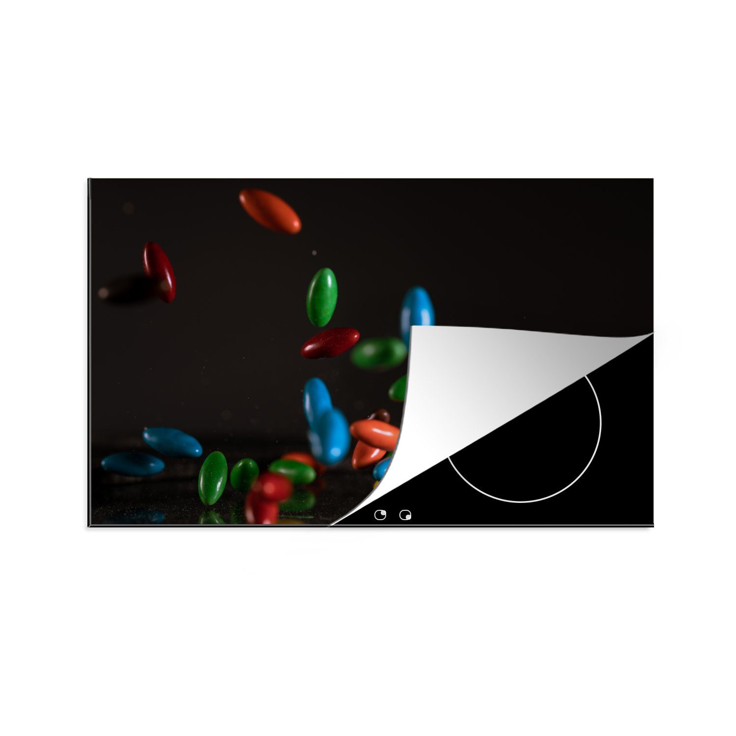 MuchoWow Herdblende-/Abdeckplatte Fallende Schokoladenbonbons auf schwarzem Hintergrund, Vinyl, (1 tlg), 81x52 cm, Induktionskochfeld Schutz für die küche, Ceranfeldabdeckung