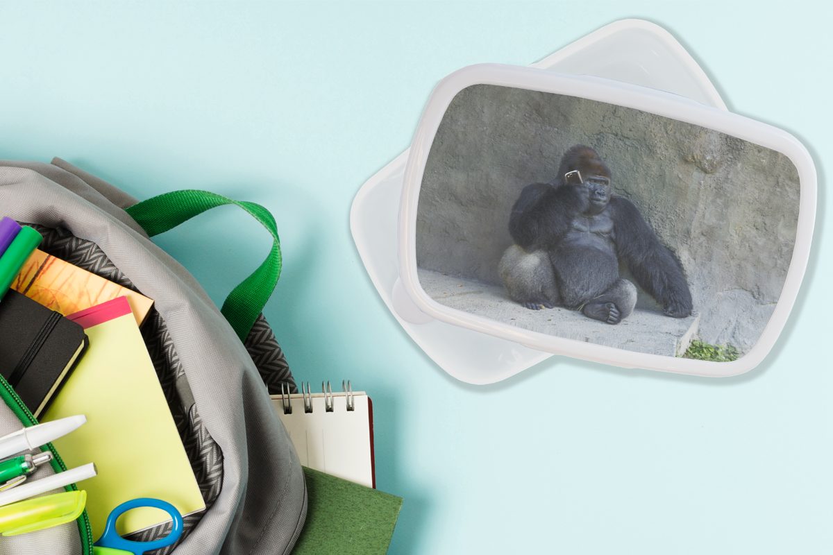 MuchoWow Lunchbox Ein riesiger Gorilla für lehnt weiß Brotdose, Jungs Mädchen Kinder Kunststoff, Erwachsene, (2-tlg), für an Brotbox einer und Steinmauer, und
