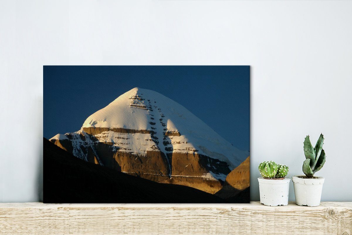 OneMillionCanvasses® Leinwandbild Sonnenstrahlen, die cm Leinwandbilder, des den Wanddeko, fallen, auf Wandbild (1 Tibet 30x20 St), Berges in Kailash Aufhängefertig, Gipfel