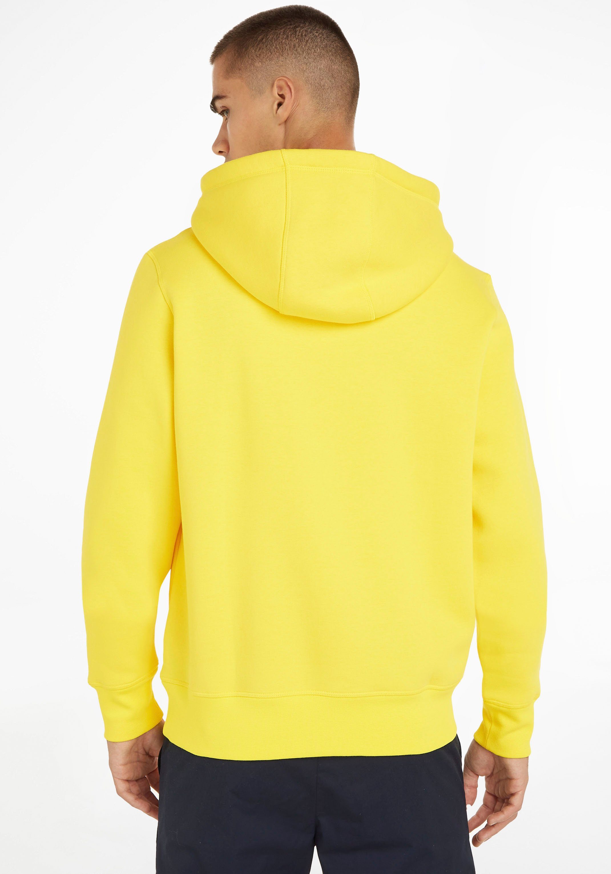 Tommy Hilfiger Kapuzensweatshirt TOMMY LOGO Yellow der mit gesticktem TH-Schriftzug auf Vivid Brust HOODY