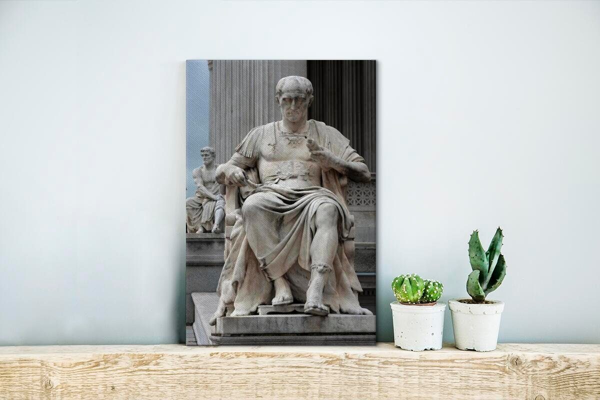 OneMillionCanvasses® Leinwandbild Eine cm Zackenaufhänger, sitzend, von Leinwandbild St), Julius (1 Statue bespannt 20x30 Caesar fertig inkl. Gemälde