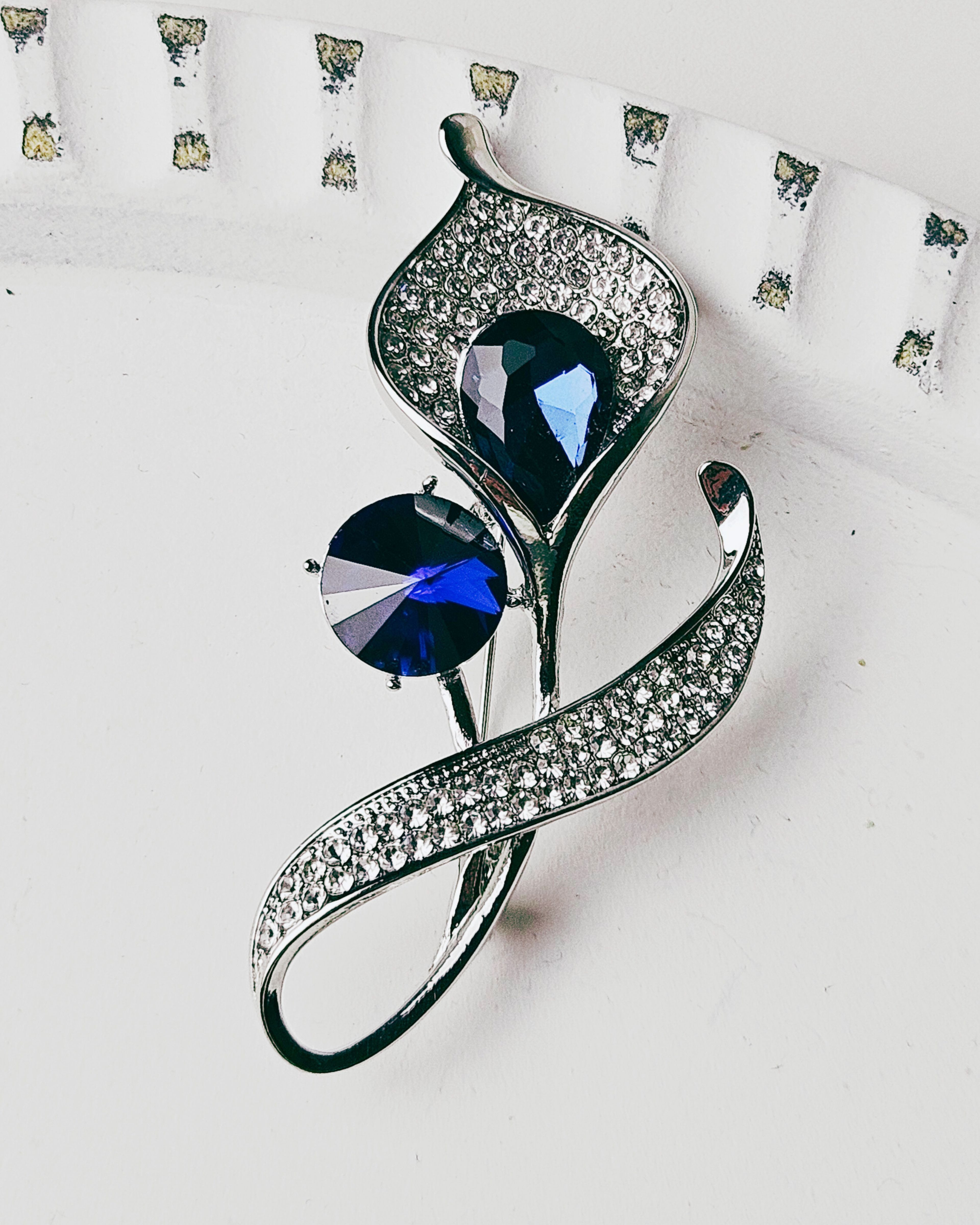 MayTree Brosche "Calla", weiß mit zwei blauen Strasssteinen (Stück, 1-tlg), Metallbrosche mit Strass und einem Glassstein