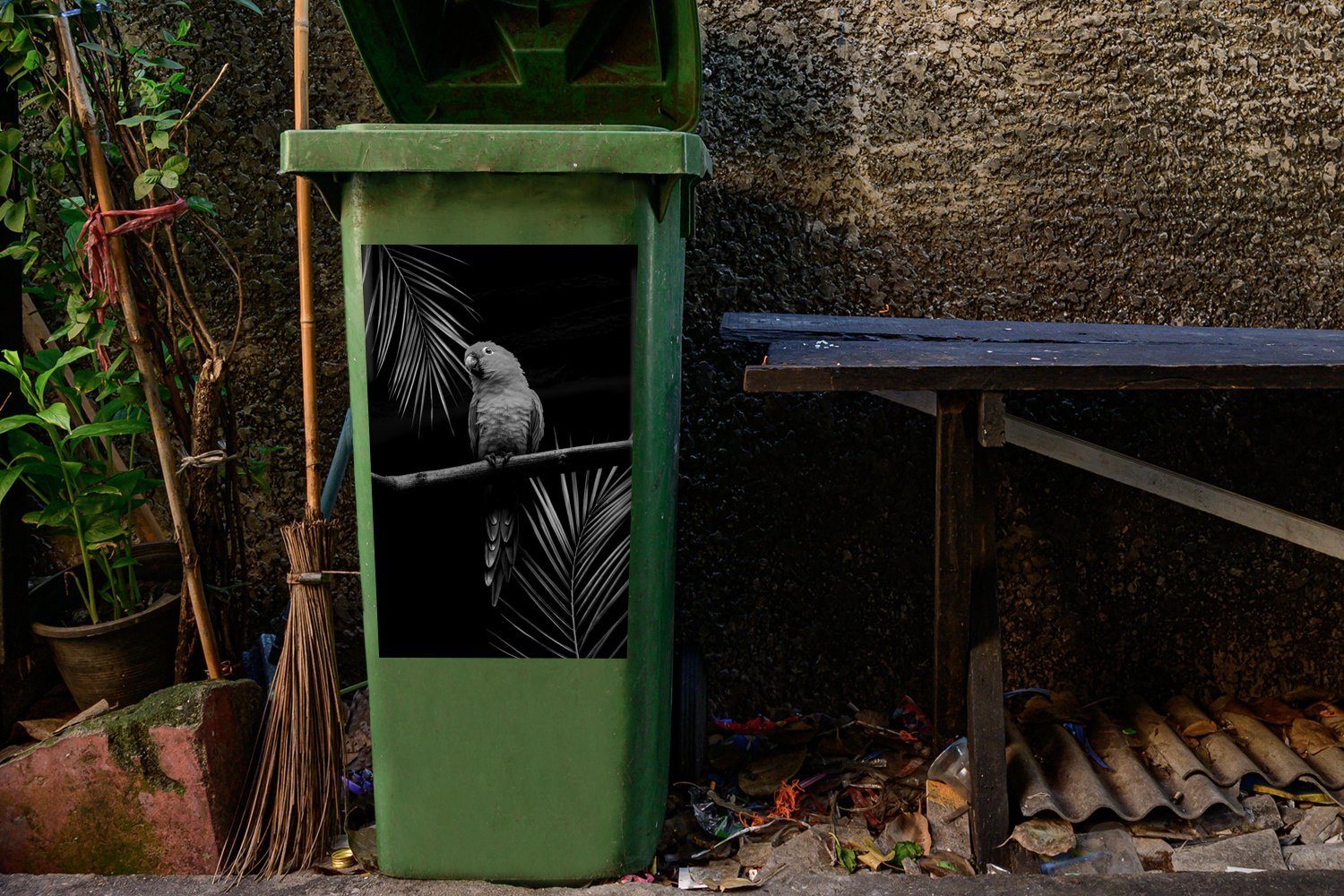 schwarzen Abfalbehälter (1 MuchoWow - Hintergrund Sticker, vor sitzt Zweig einem St), einem Container, Mülltonne, Papagei Ein Wandsticker Mülleimer-aufkleber, auf