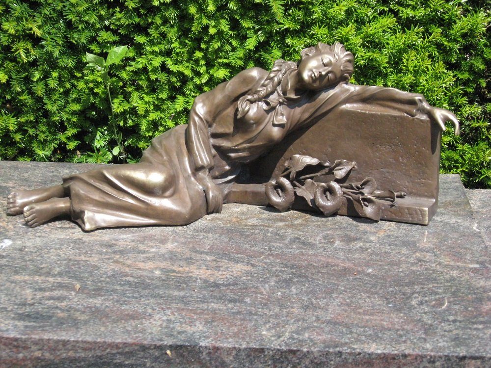 Skulptur Bronzefigur liegende Frau am Grabstein