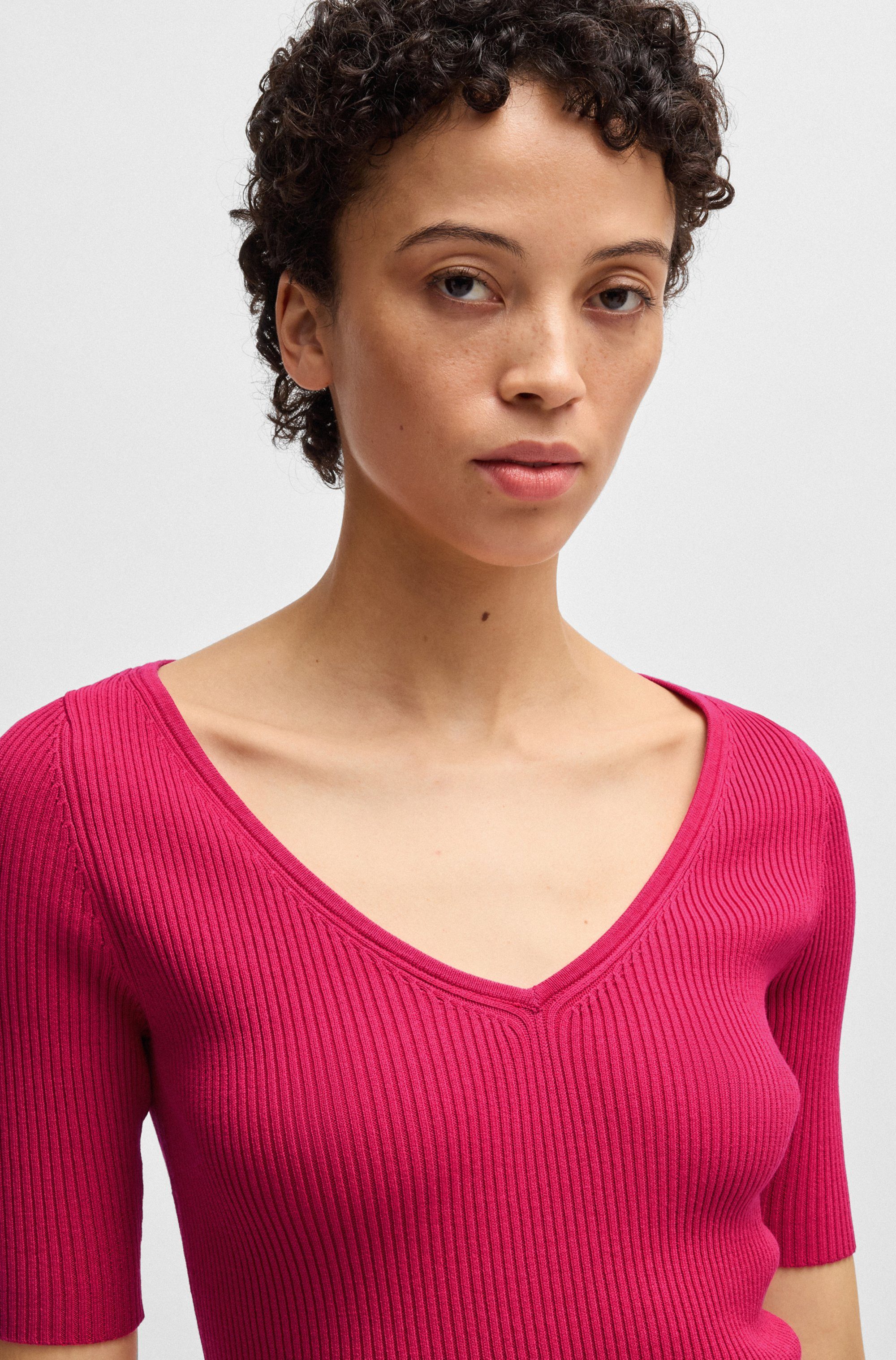 BOSS ORANGE Strickpullover Faradisco Premium Damenmode mit BOSS Metallcharm