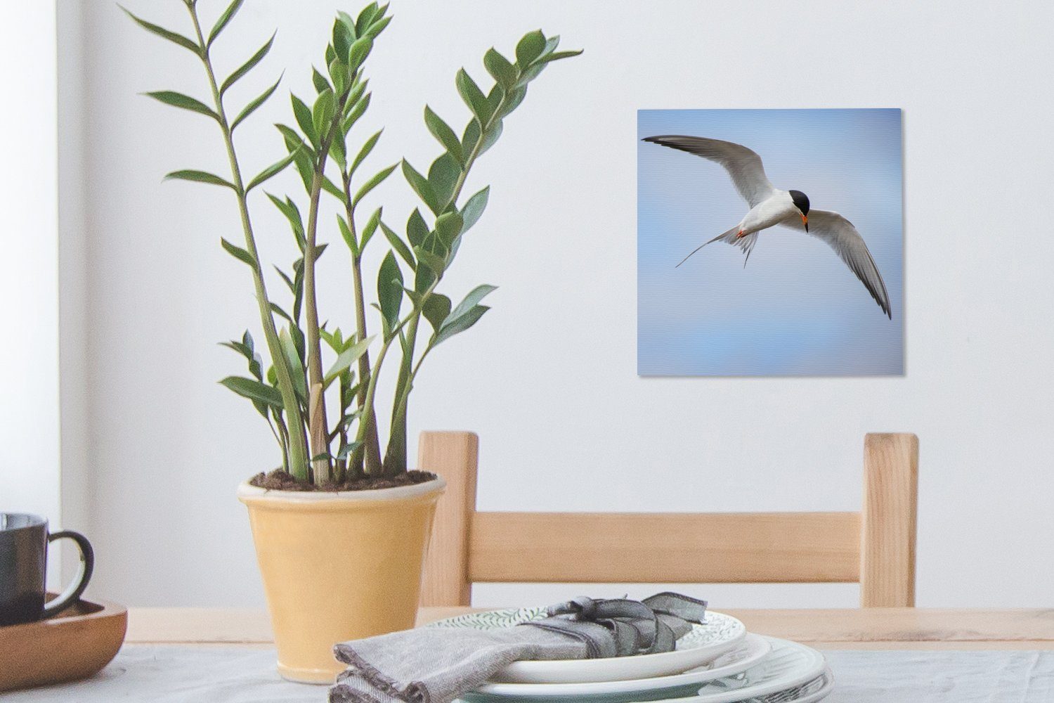 OneMillionCanvasses® Leinwandbild Eine Weißflügelseeschwalbe fliegt Bilder Leinwand Schlafzimmer St), Himmel, Wohnzimmer blauen für am (1