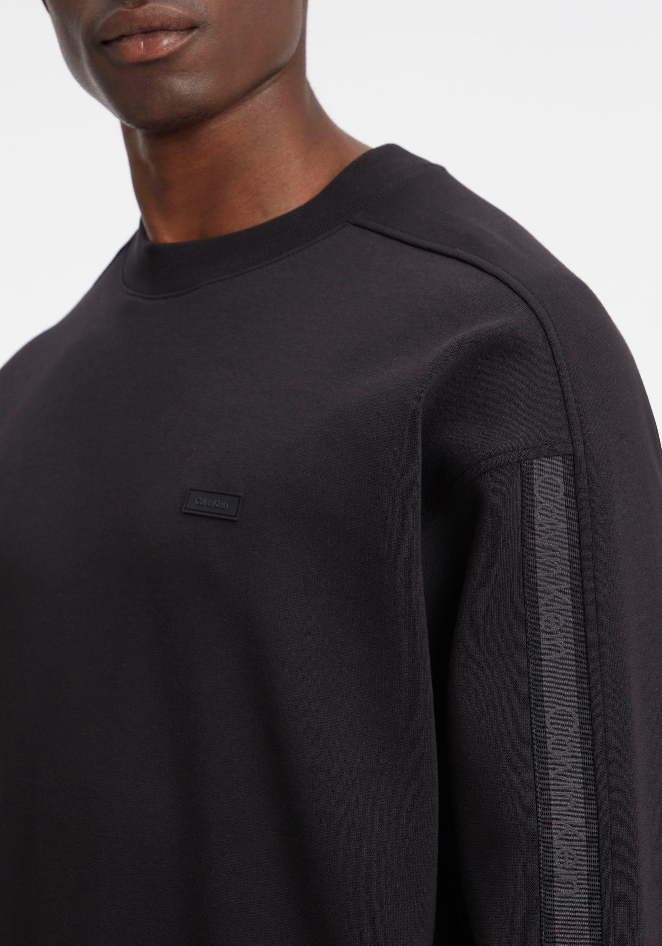 Calvin Klein Sweatshirt TAPE LOGO COMFORT Ärmel schwarz SWEATSHIRT am Logo-Streifen mit