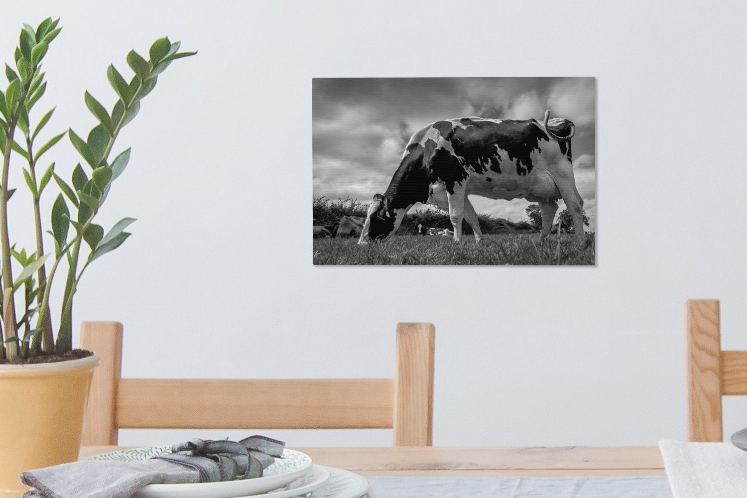 OneMillionCanvasses® Leinwandbild Eine Friesenkuh mit bunt dunklen Wandbild 30x20 schwarz - (1 weiß, Aufhängefertig, cm Leinwandbilder, Wolken ihr St), Wanddeko, und über