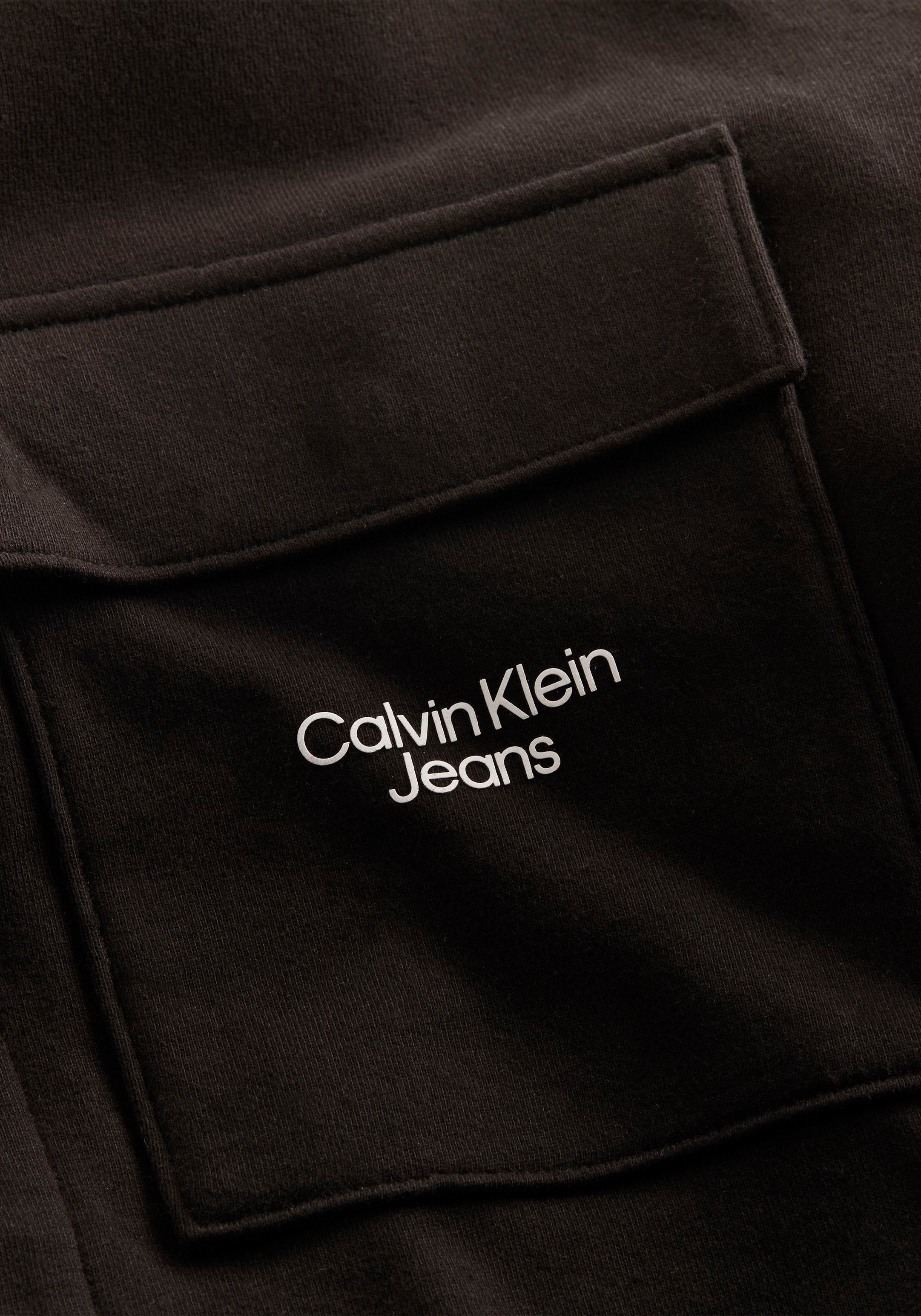 auf der Calvin Logoschriftzug STACKED mit LOGO Klein HOODED Calvin OVERSHIRT Jeans Oversize-Shirt Klein Brusttasche