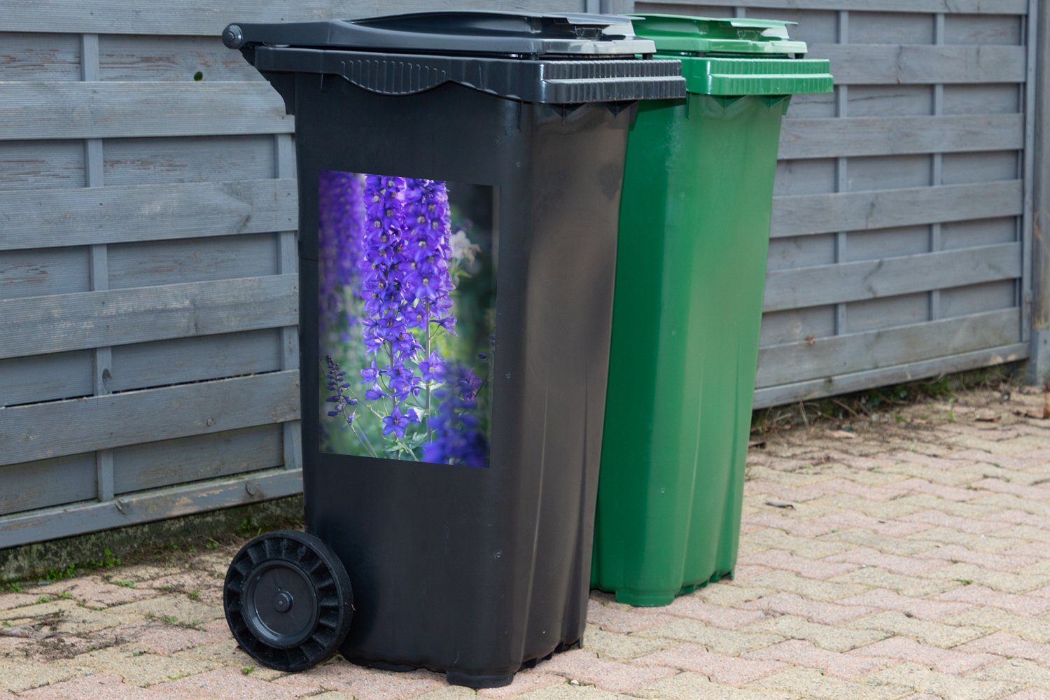 MuchoWow Wandsticker Lila Rittersporn blüht Container, Mülleimer-aufkleber, Sticker, in grünen Landschaft Mülltonne, einer Abfalbehälter (1 St)