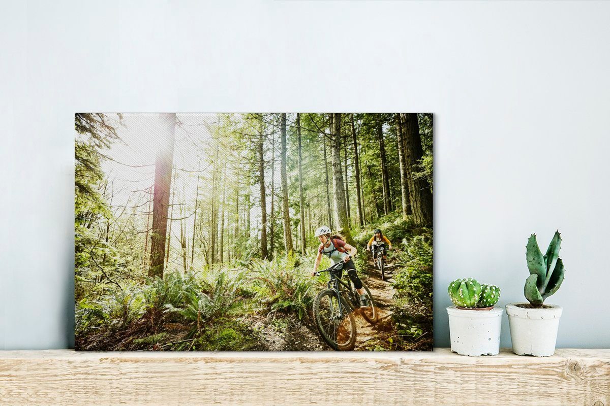 OneMillionCanvasses® Leinwandbild Zwei Frauen auf St), Aufhängefertig, (1 Mountainbikes cm den durch Wandbild 30x20 Wald, Wanddeko, Leinwandbilder