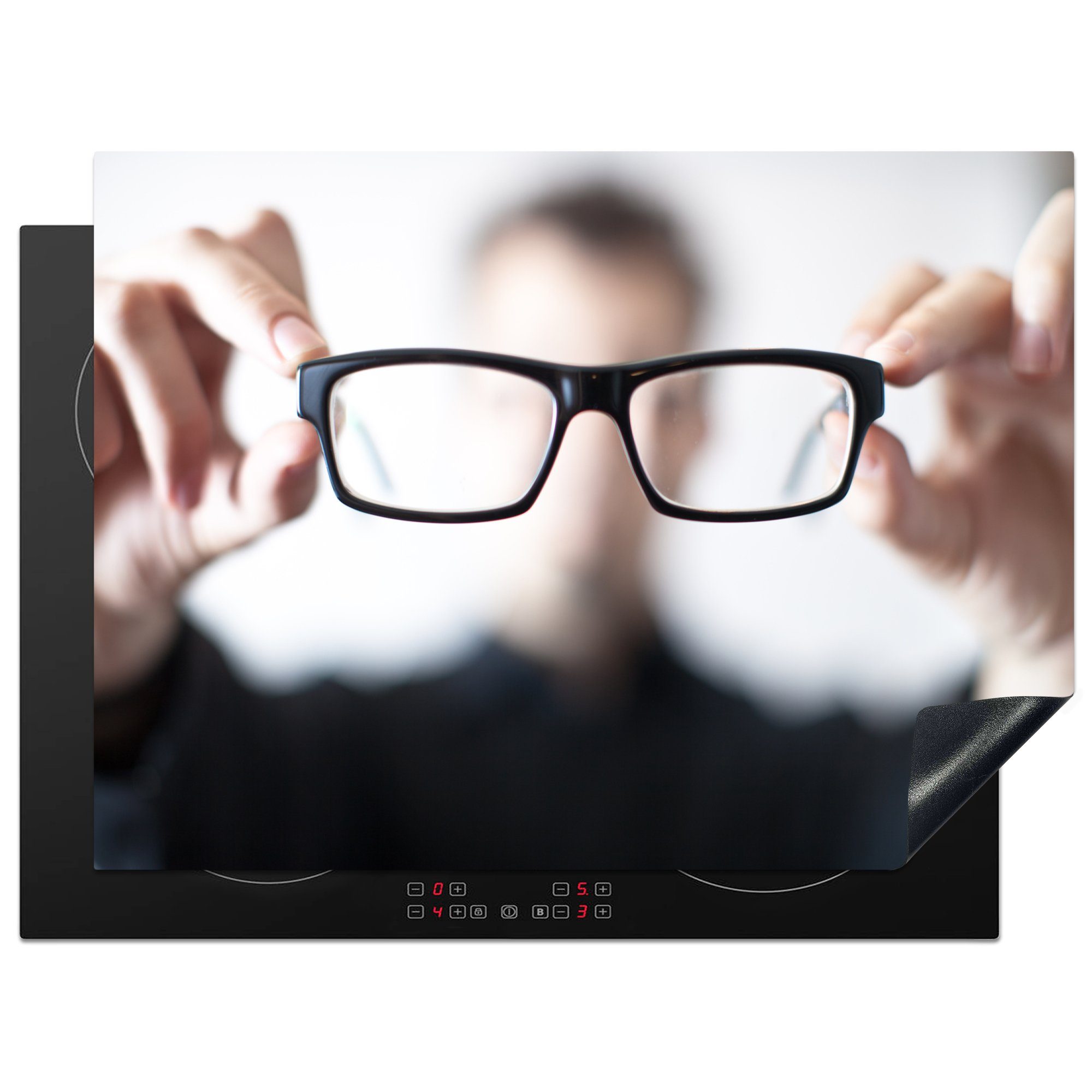 MuchoWow Herdblende-/Abdeckplatte Nahaufnahme eines Mannes, der eine Brille trägt und sie der Kamera, Vinyl, (1 tlg), 70x52 cm, Mobile Arbeitsfläche nutzbar, Ceranfeldabdeckung