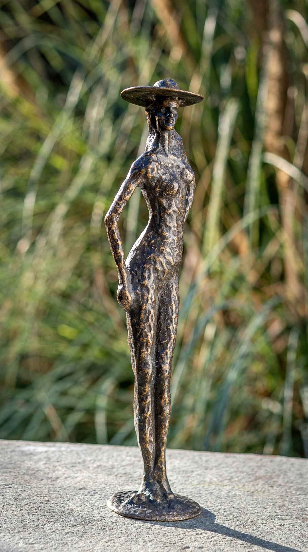 IDYL Gartenfigur IDYL Bronze-Skulptur Moderne robust – mit – von in Bronze Regen und patiniert. Langlebig Modelle gegossen gegen Wachsausschmelzverfahren Frau in Bronze witterungsbeständig sehr UV-Strahlung. Frost, Die – und Hand werden Hut