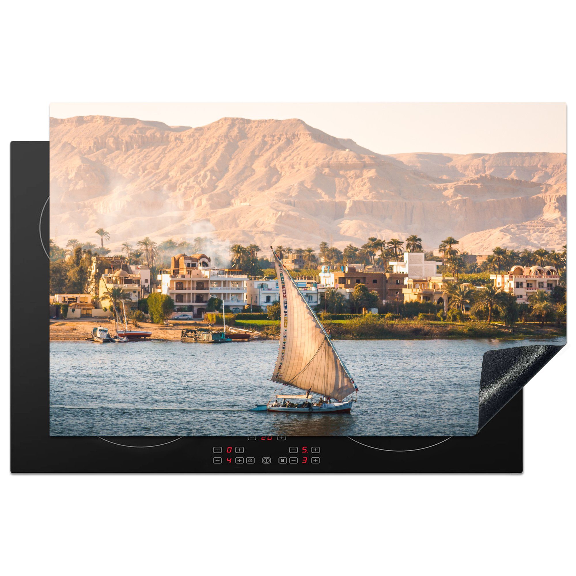 MuchoWow Herdblende-/Abdeckplatte Ein Segelboot segelt den Nil in der Nähe einer Stadt hinunter, Vinyl, (1 tlg), 81x52 cm, Induktionskochfeld Schutz für die küche, Ceranfeldabdeckung
