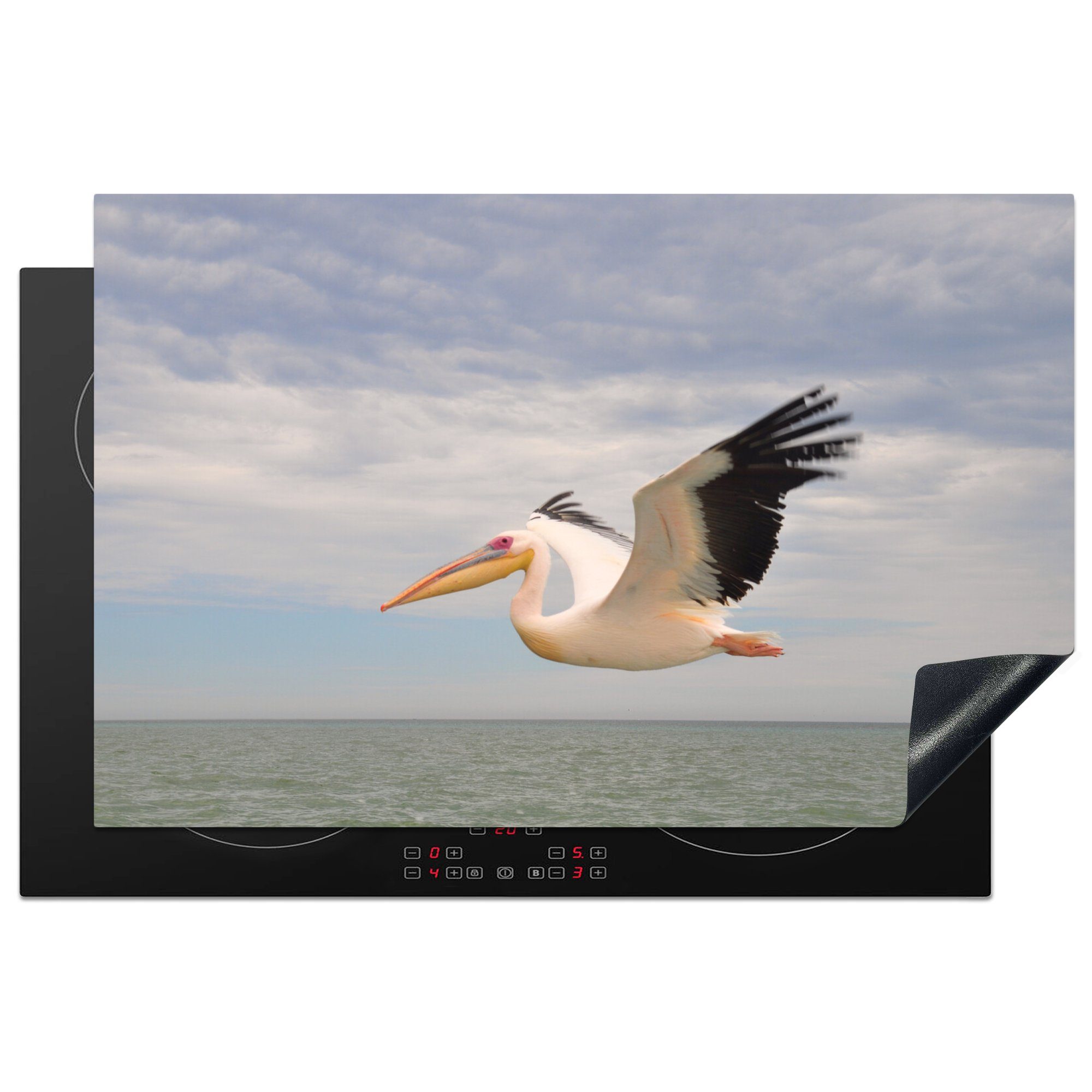 MuchoWow Herdblende-/Abdeckplatte Fliegender Pelikan über dem Meer in Namibia, Vinyl, (1 tlg), 81x52 cm, Induktionskochfeld Schutz für die küche, Ceranfeldabdeckung