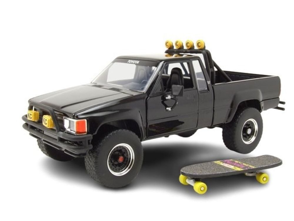 JADA Modellauto Toyota SR5 Pick Up 1985 schwarz mit Skateboard Zurück in die Zukunft, Maßstab 1:24