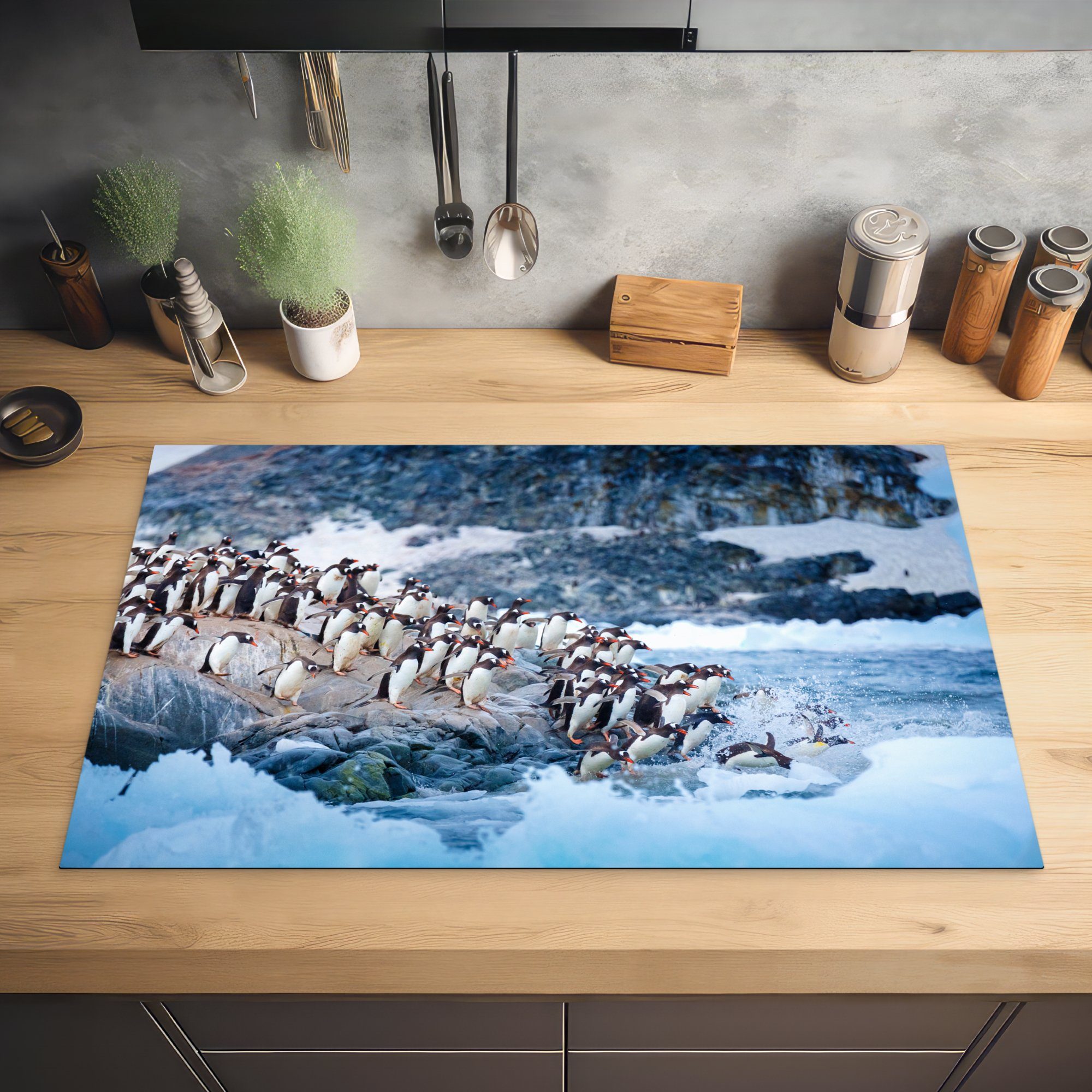 von taucht tlg), ins Eine Ceranfeldabdeckung, Gruppe für Arbeitsplatte Pinguinen (1 cm, Herdblende-/Abdeckplatte 83x51 einem Vinyl, Felsen MuchoWow Wasser, küche von