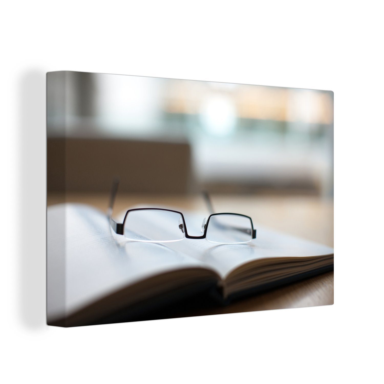 OneMillionCanvasses® Leinwandbild Eine Lesebrille liegt auf einem Buch in einem Konferenzraum, (1 St), Wandbild Leinwandbilder, Aufhängefertig, Wanddeko, 30x20 cm