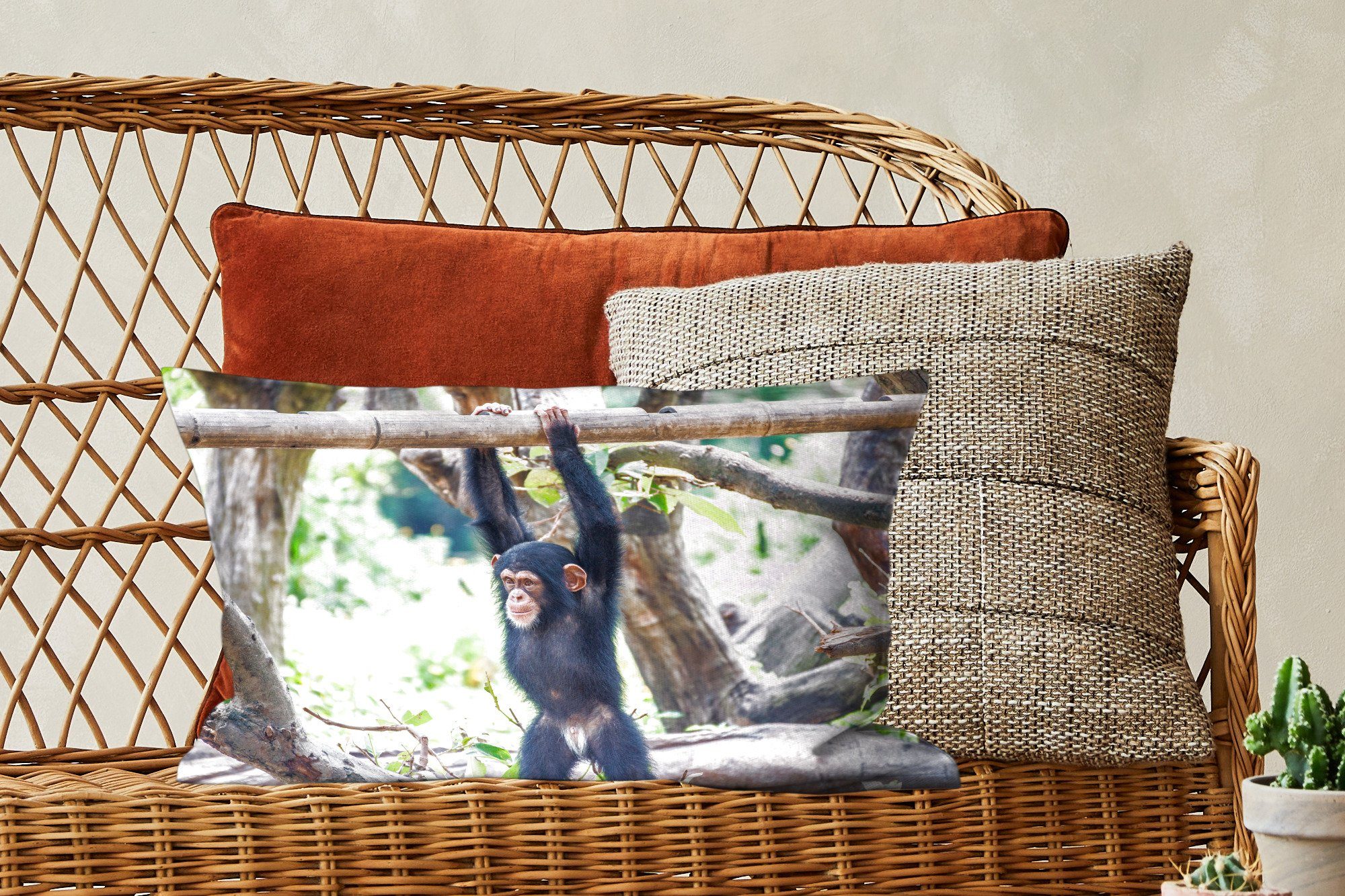 der Schlafzimmer Schimpanse an Natur, Füllung, MuchoWow Ein junger Dekokissen Ast hängt Zierkissen, Dekoration, einem mit inmitten Dekokissen Wohzimmer