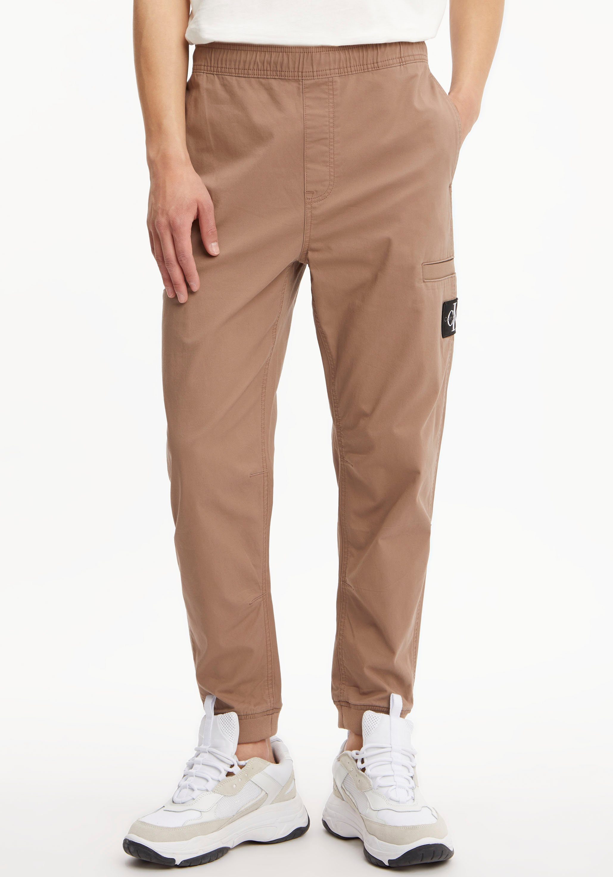 Calvin Klein Jeans Jogginghose Warm ELASTIC WOVEN mit PANT Toffee auf Logo-Badge Bein BADGE dem Calvin TRIM Klein